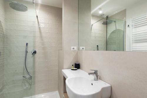 uma casa de banho branca com um lavatório e um chuveiro em Acate81 Lifestyle Apartment em Nápoles