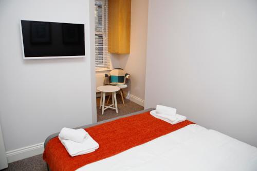 a bedroom with a bed with a red blanket at Soho Chambers by Indigo Flats in London