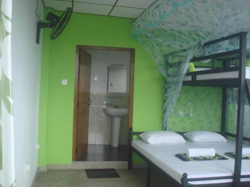 a bedroom with a bunk bed and a bathroom at Hiranya Mountain View Hostel Kandy in Kandy