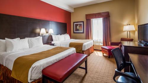 a hotel room with two beds and a desk at Best Western Plus Bowmanville in Bowmanville
