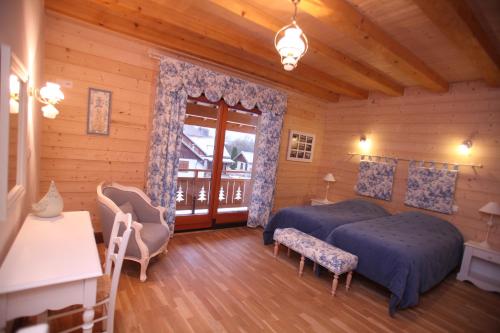 a bedroom with two beds and a balcony at La Tour du Coq Doré in Granges-Narboz