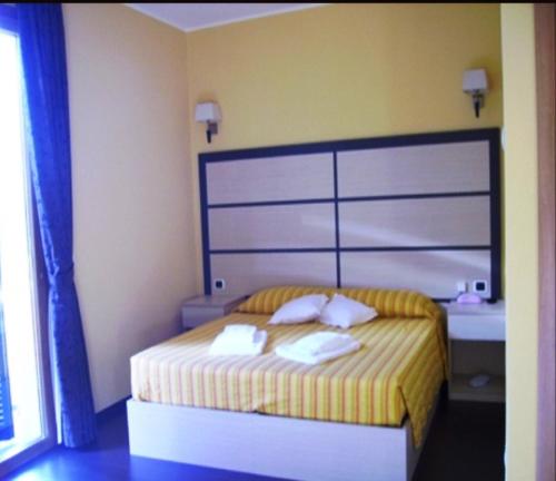 a bedroom with a bed with two towels on it at Hotel La Solitaria in Carlazzo