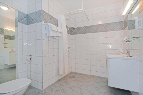 a bathroom with a shower and a toilet and a sink at Chesterfield Hotel in Trondheim