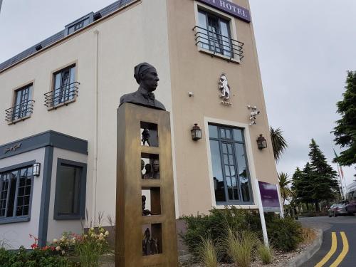 a statue of a man standing in front of a building at Talbot Hotel Stillorgan in Stillorgan