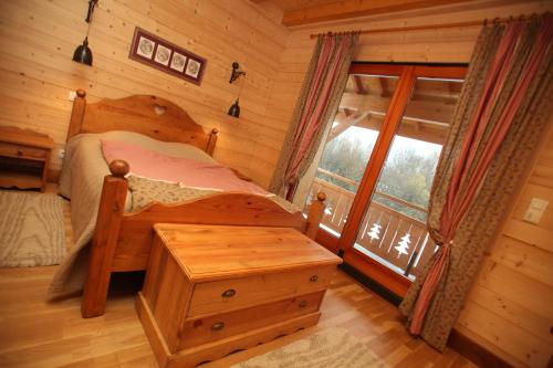 a bedroom with a bed in a log cabin at La Tour du Coq Doré in Granges-Narboz