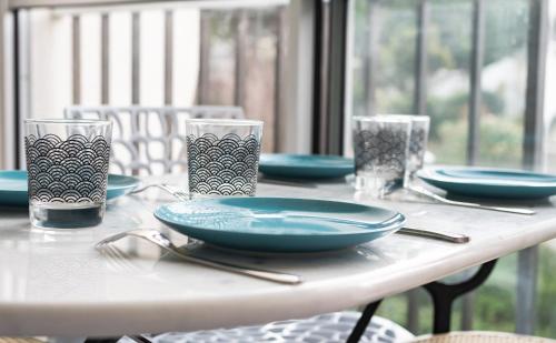 ラ・グランド・モットにあるLe Magellanの白いテーブル(青い皿とメガネ付)