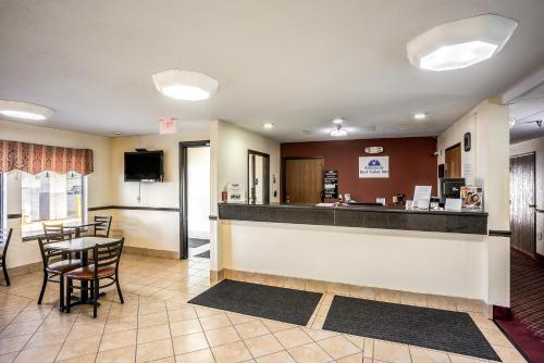 a kitchen with a table and chairs and a refrigerator at Americas Best Value Inn-Galesburg in Galesburg