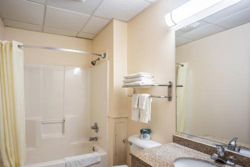 a bathroom with a sink and a tub and a toilet at American inn and suites in Galesburg