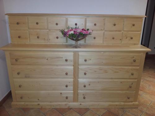 a dresser with a vase of flowers on top of it at Agriturismo Prato degli Angeli in Sassoleone