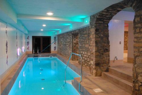 a swimming pool in a building with a stone wall at Agriturismo Prato degli Angeli in Sassoleone