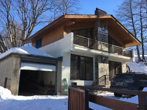 a house with a garage in the snow at Вилла с комфортом in Bakuriani