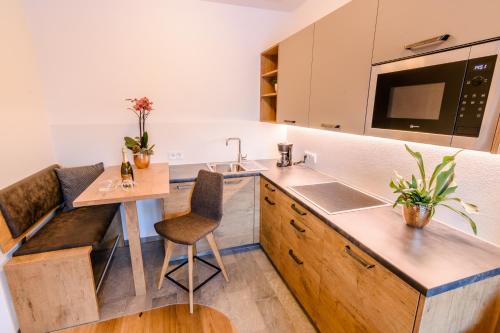 a kitchen with a sink and a table with chairs at Mair am Anger-Appartments in Riscone