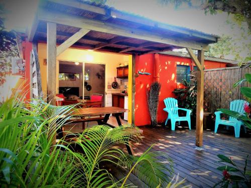 a patio with a wooden table and chairs on a deck at Les Manguiers in Deshaies