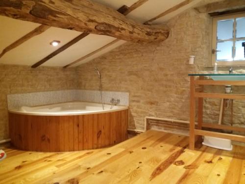 eine Badewanne in einem Zimmer mit Holzboden in der Unterkunft La Pommeraie in Nantillé