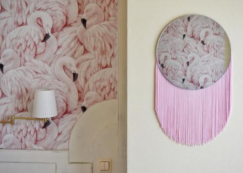 a pink flamingos mural on a wall with a mirror at Hotel Maria Luisa in Burgos