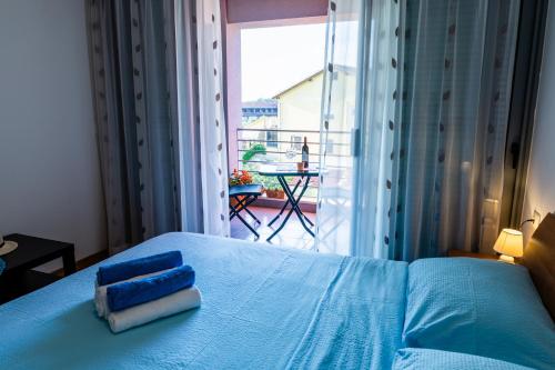 a bedroom with a blue bed with a view of a balcony at APP - 1 in Novigrad Istria