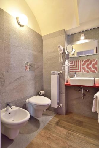 a bathroom with a white toilet and a sink at Modica Old Town Rooms in Modica
