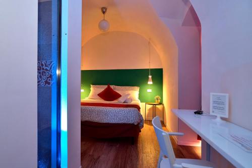 a bedroom with a bed with a green headboard at Modica Old Town Rooms in Modica