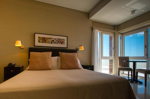 un dormitorio con cama y una gran ventana en el Hotel Bahia de Villa Gesell
