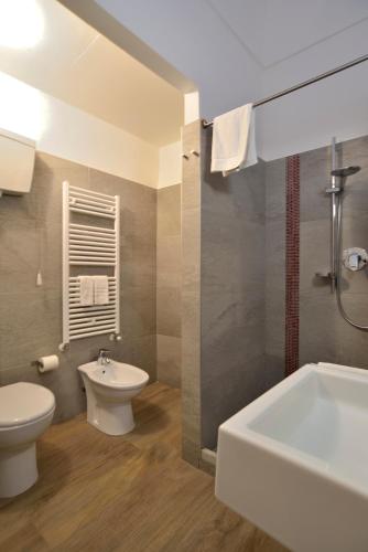 a bathroom with a toilet and a sink and a tub at Modica Old Town Rooms in Modica