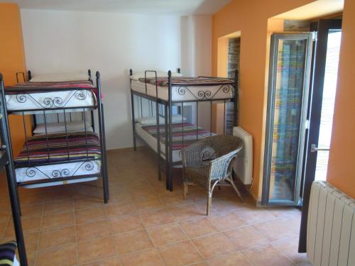 a room with two bunk beds and a chair at Albergue O Durmiñento in Sarria