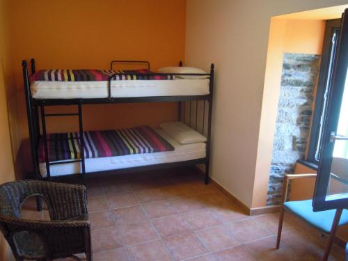 two bunk beds in a room with a chair at Albergue O Durmiñento in Sarria