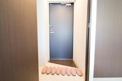 lustro w łazience z drzwiami i rzędem toalet w obiekcie Sannand / Vacation STAY 2187 w mieście Sapporo