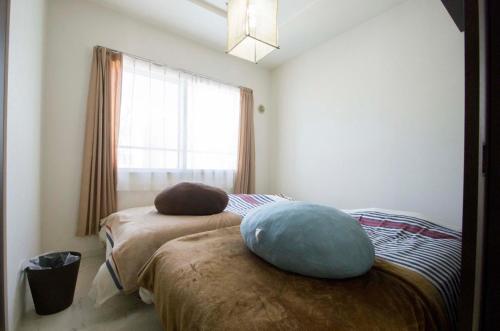 ein Schlafzimmer mit einem Bett mit einem Kissen darauf in der Unterkunft Sannand / Vacation STAY 2188 in Sapporo