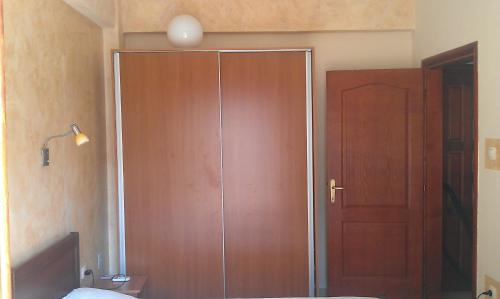 a large wooden closet in a bedroom with a door at Apartment 60m from sea! in Nea Kalikratia