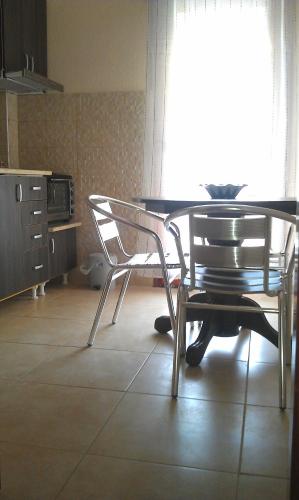a dining room table and two chairs in a kitchen at Apartment 60m from sea! in Nea Kalikratia