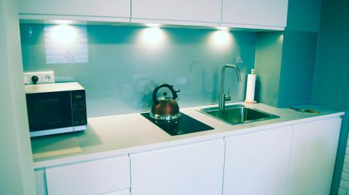 a kitchen with a microwave and a tea kettle at Apartamenty Topaz in Krynica Zdrój