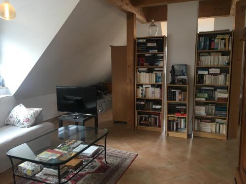 uma sala de estar com um sofá e uma mesa de vidro em Helle und ruhige Dachgeschosswohnung em Munique