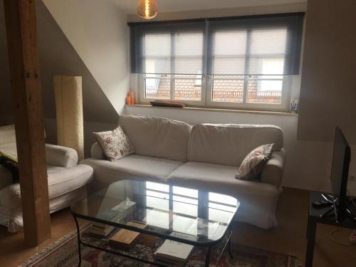 a living room with a couch and a glass table at Helle und ruhige Dachgeschosswohnung in Munich