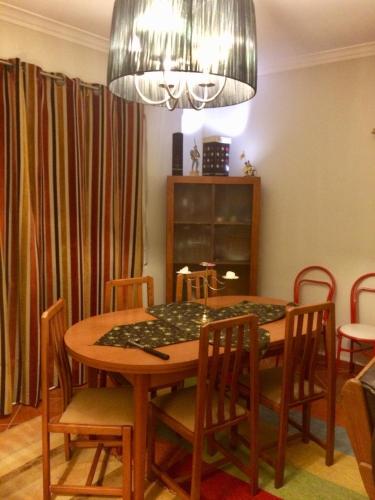 a dining room with a table and chairs under a chandelier at Templar Secrets House in Tomar