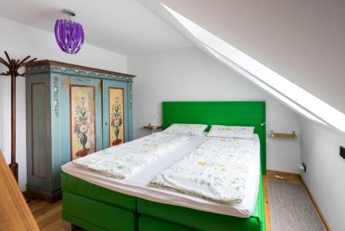a bed with a green headboard in a room at Ferienwohnung Biobauernhof Peter Anderl Hof in Pfreimd