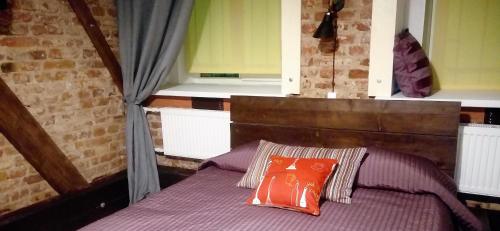 a bed with two pillows on it with two windows at Apart Hotel Arka in Saint Petersburg