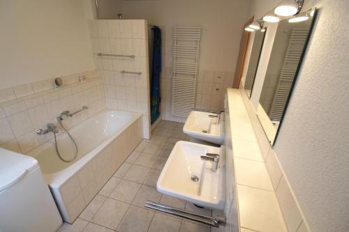 a bathroom with two sinks and a tub and a toilet at Mühlgarten in Immenstaad am Bodensee