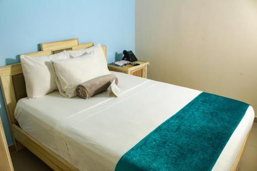 a bedroom with a large white bed and a night stand at Hotel Med Barranquilla Centro in Barranquilla