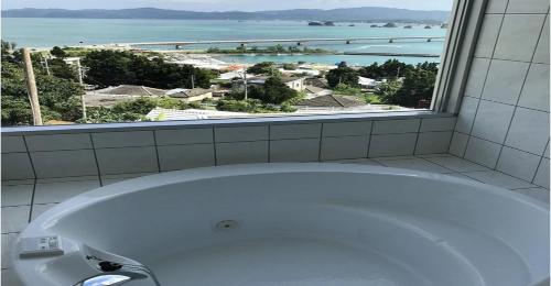 a bath tub in a bathroom with a large window at 220 Kouri Nakijin-son - Hotel / Vacation STAY 8715 in Nakijin