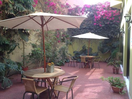 an outdoor patio with tables and chairs and umbrellas at Hotel San Francisco De la Selva in Copiapó