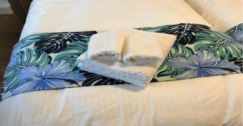 a towel sitting on top of a bed with flowers at 220 Kouri Nakijin-son - Hotel / Vacation STAY 8715 in Nakijin