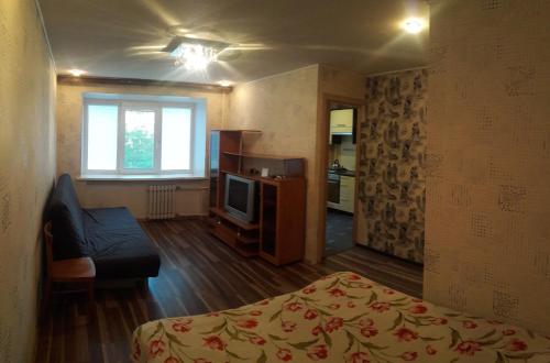 セヴェロドヴィンスクにあるKapitana Voronina 13のベッド、ソファ、テレビが備わる客室です。