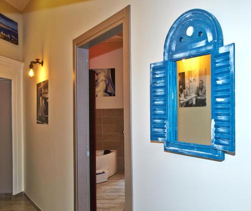 a blue mirror on a wall next to a bathroom at Artisti Sustinea Rooms in Naples