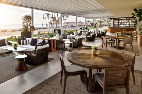 a restaurant with tables and chairs and the beach at Al Alamein Hotel in El Alamein