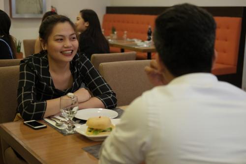 a woman sitting at a table with a plate of food at Top Star Hotel in Cabanatuan