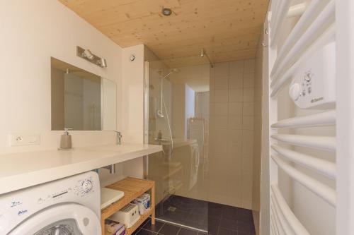 a bathroom with a sink and a washing machine at Loft Coco in Luchon