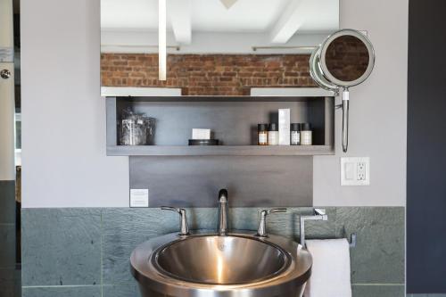 a sink in a bathroom with a mirror at Hotel le Priori in Quebec City