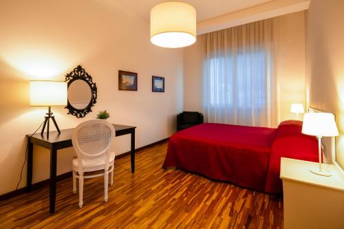 a bedroom with a red bed and a table and a mirror at Culture Residence Consalvo Otto in Naples