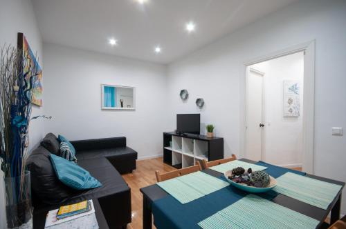 een woonkamer met een tafel en een bank bij Acogedor Apartamento Lavapies in Madrid