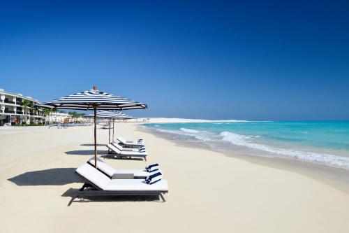 - un ensemble de chaises longues et d'un parasol sur la plage dans l'établissement Al Alamein Hotel, à El Alamein